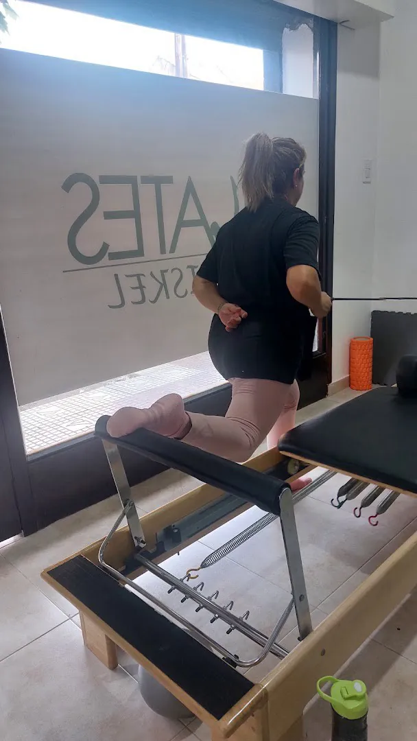 Una alumna de espaldas frente a la vidriera con el logo de Pilates Triskel